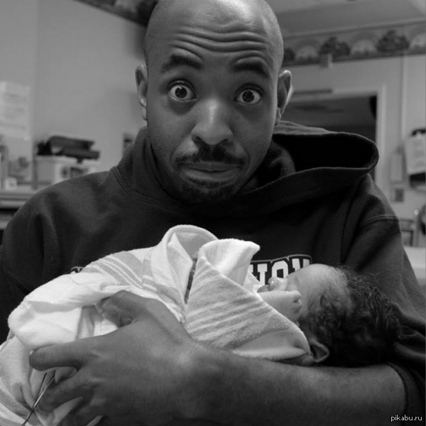 Молодой папаша Папа держит ребенка на руках