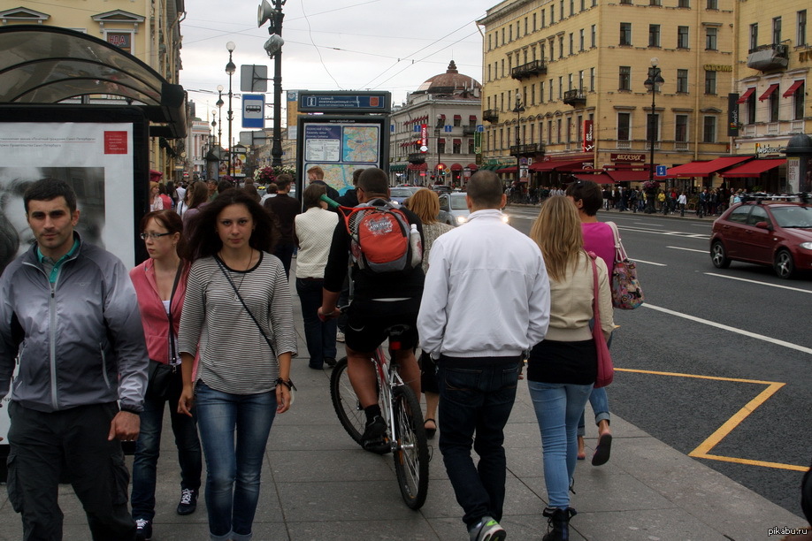 Велосипедисты на тротуаре. Люди на улице. Люди идут по тротуару. Пешеходы на улице. Люди на улице города.