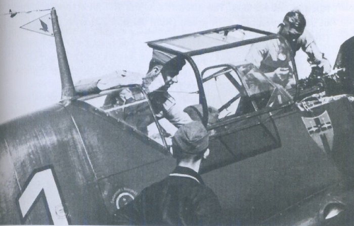 Оберлейтенант Георг Шнайдер, командир 3./JG21, в своём Bf109D-1. Треугольный вымпел с изображением пикирующего орла на антенне обозначает штаффелькапитана. Эмблема была заимствована у JG1, но белый фон заменили на красный.
