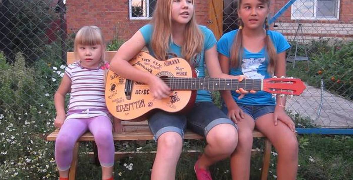 А музыка играет громко в стороне слушать. Две девочки поют. Дети поют во дворе. Маленькая девочка поет под гитару. Самая красивая девчонка со двора.
